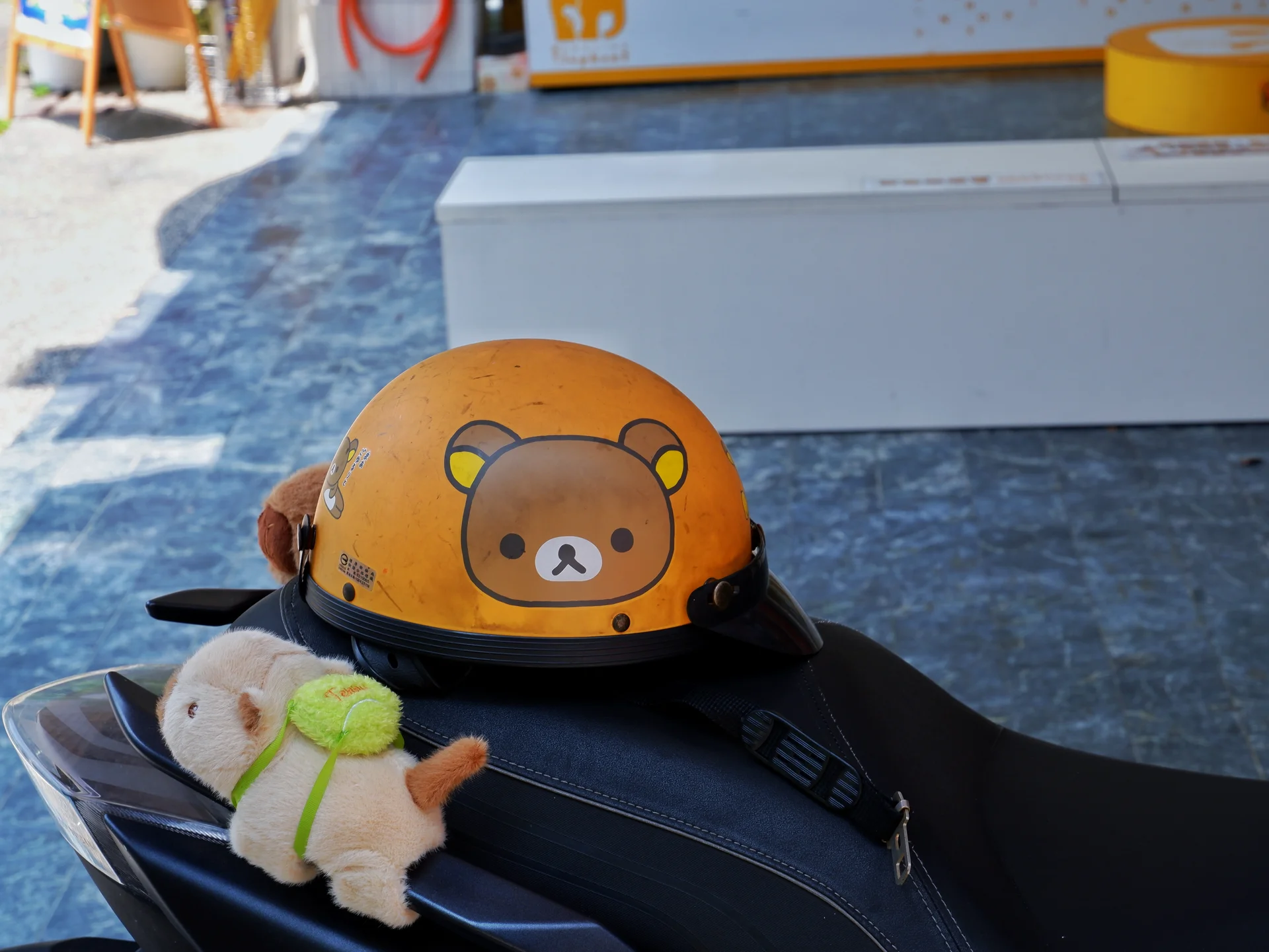 An orange helmet with a small plush toy
