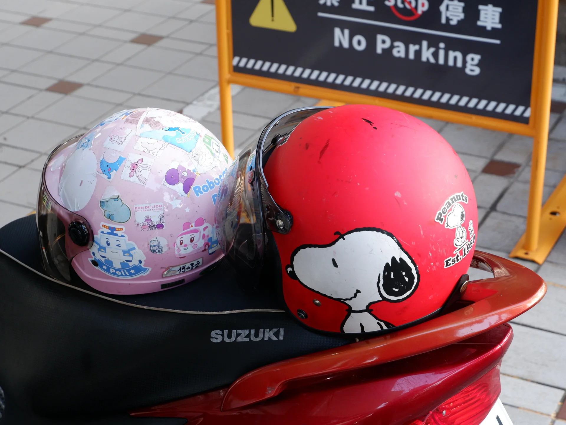 Two colorful helmets on a scooter