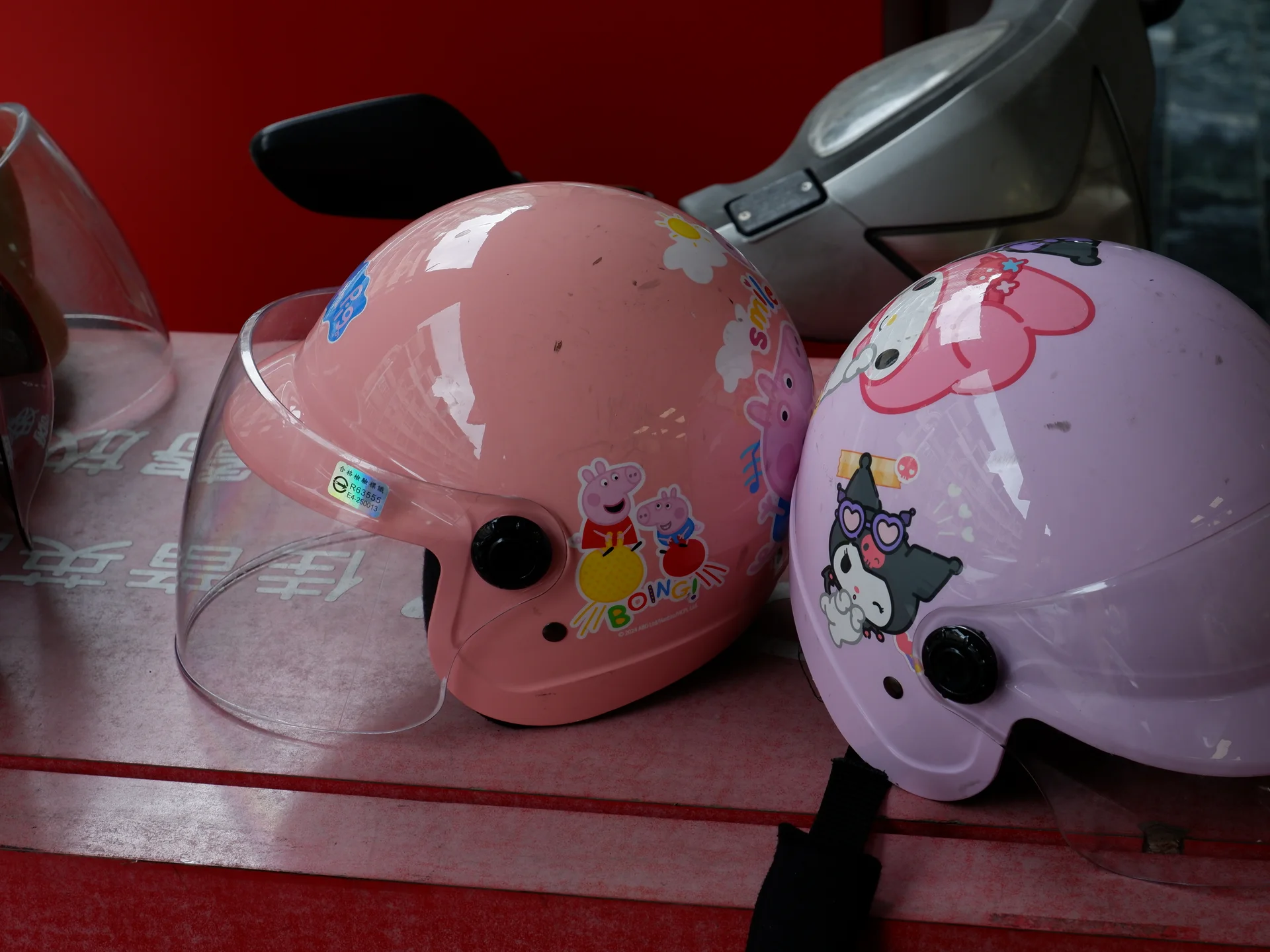 Two pastel helmets on a scooter