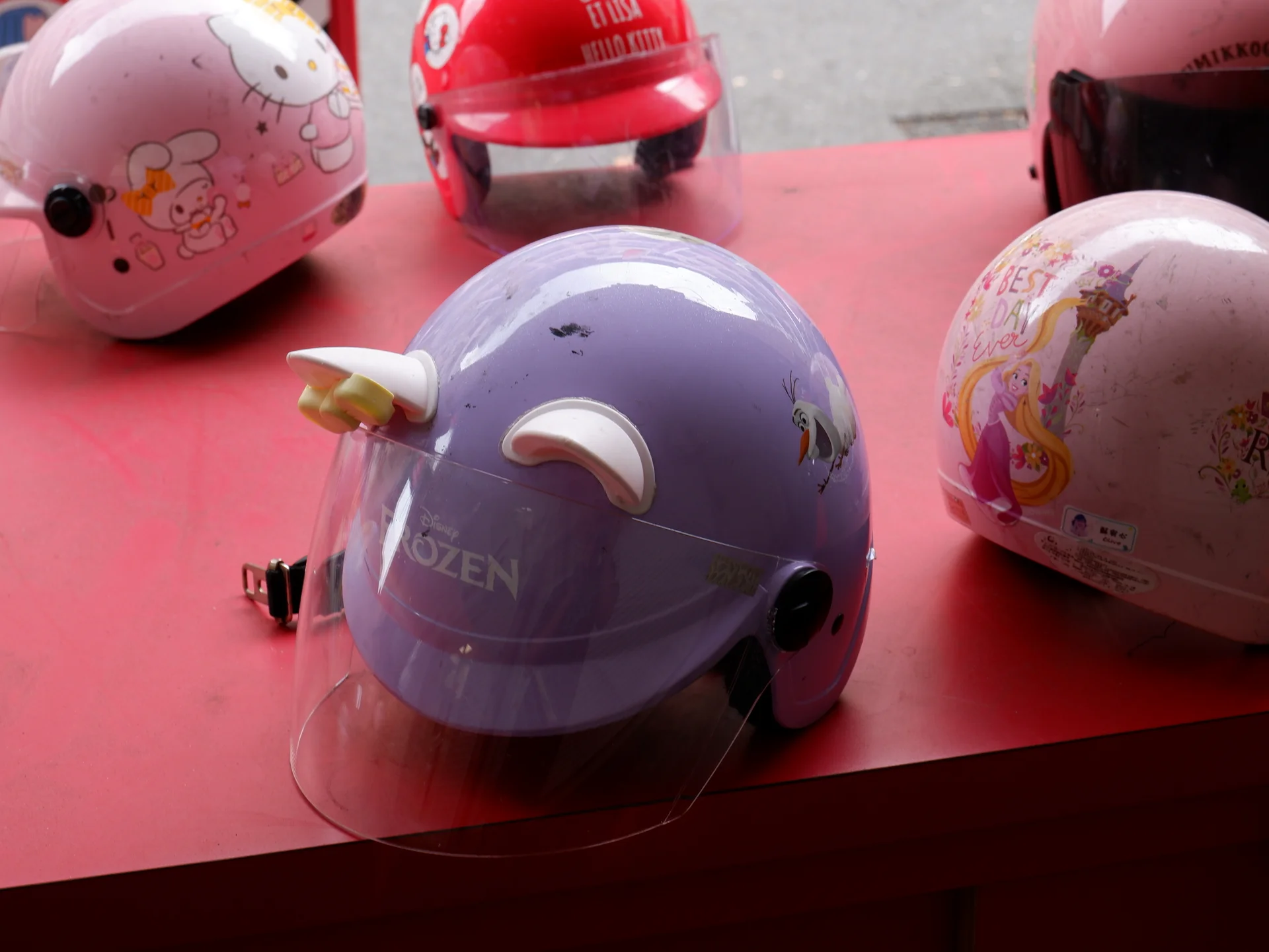 Several pastel helmets on a red surface