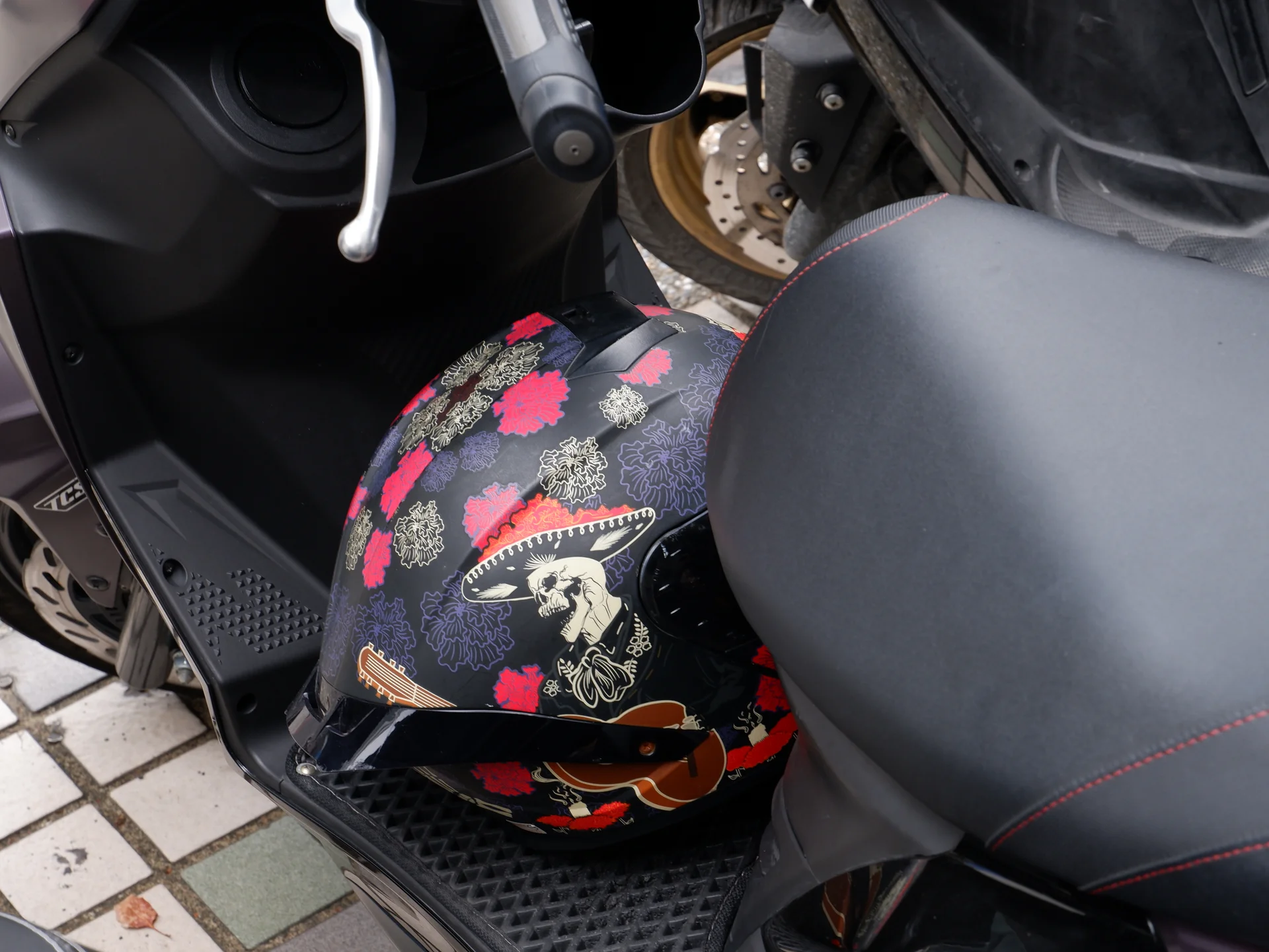 A floral helmet on a scooter